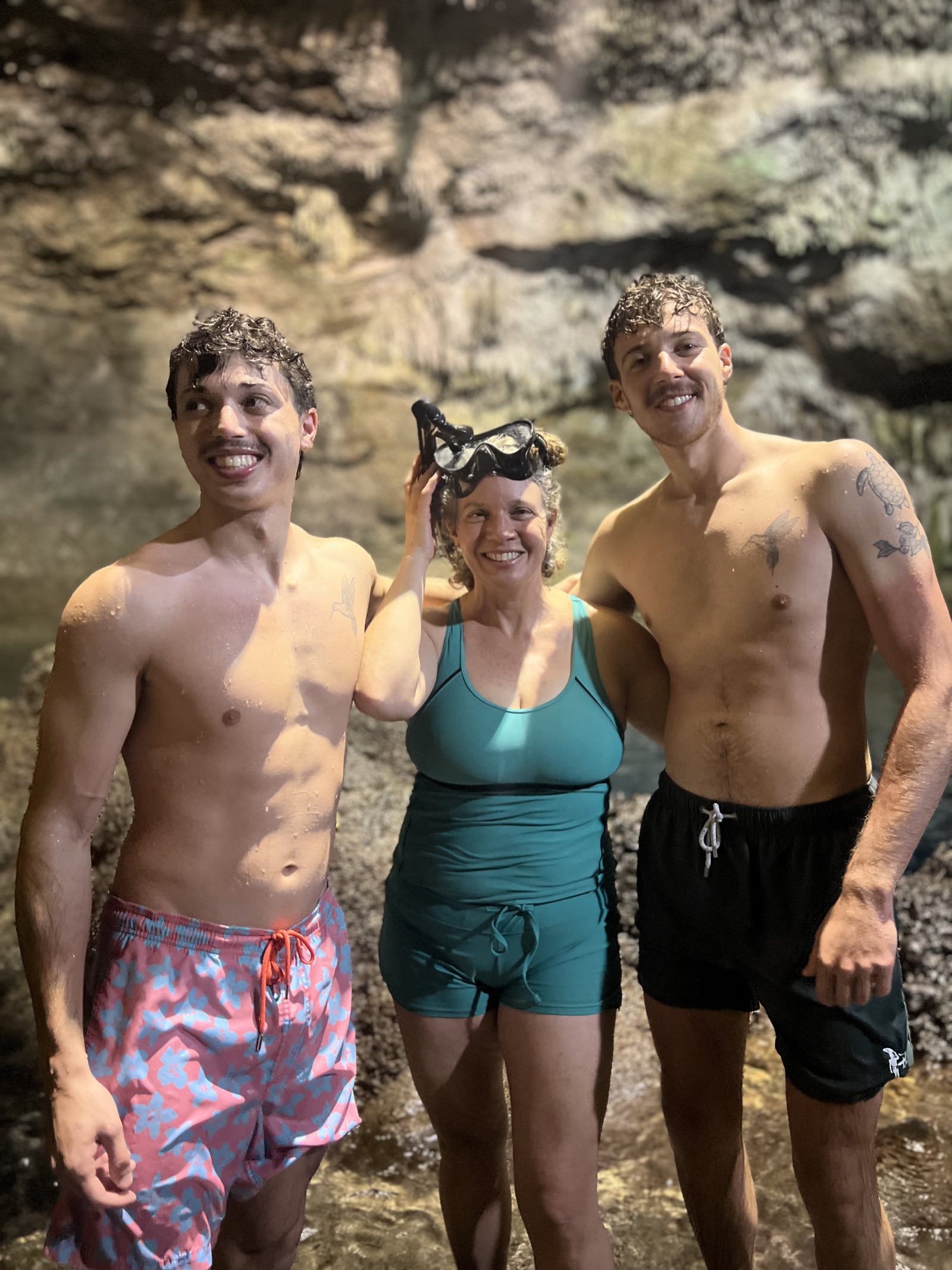 Friends swimming together in an illuminated cave cenote near Tulum