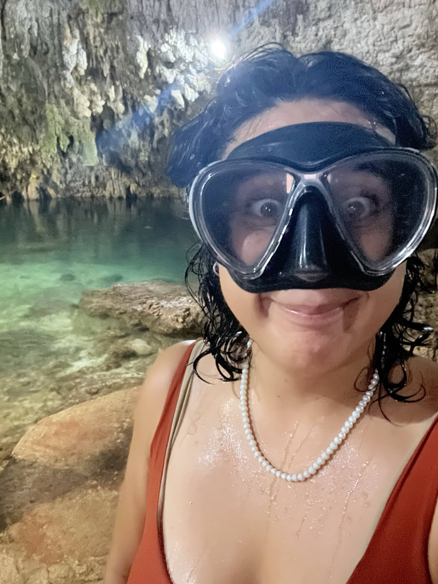 Guide smiling in a snorkel mask inside a cave cenote near Tulum