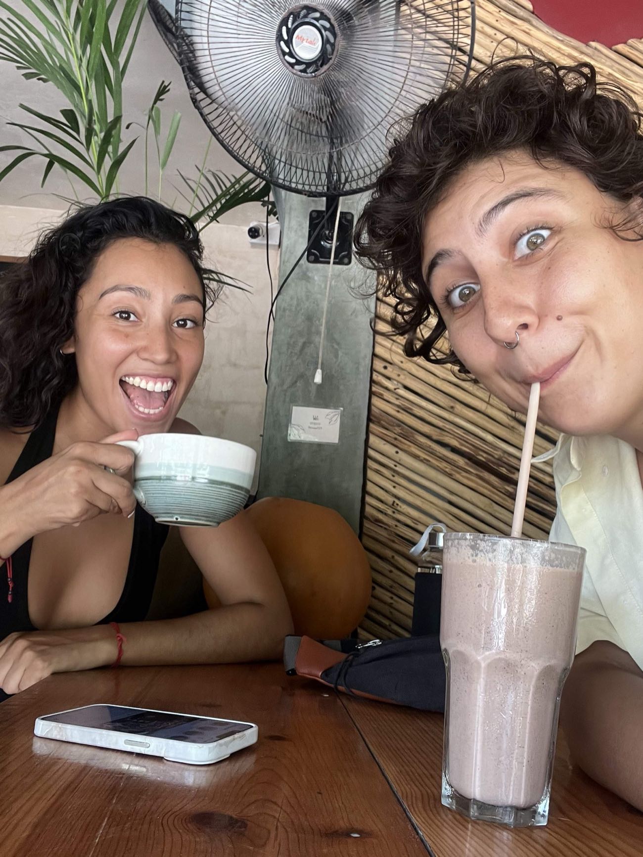 Guests laughing over coffee and smoothies at a local Tulum cafe