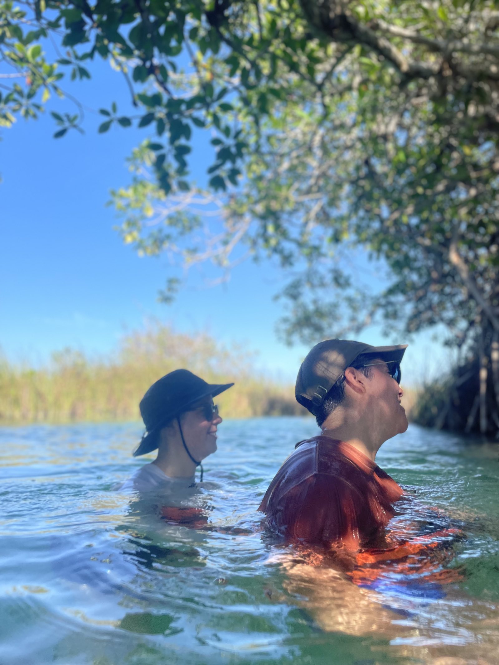 Two friends floating and laughing together in the mangrove canals at Muyil