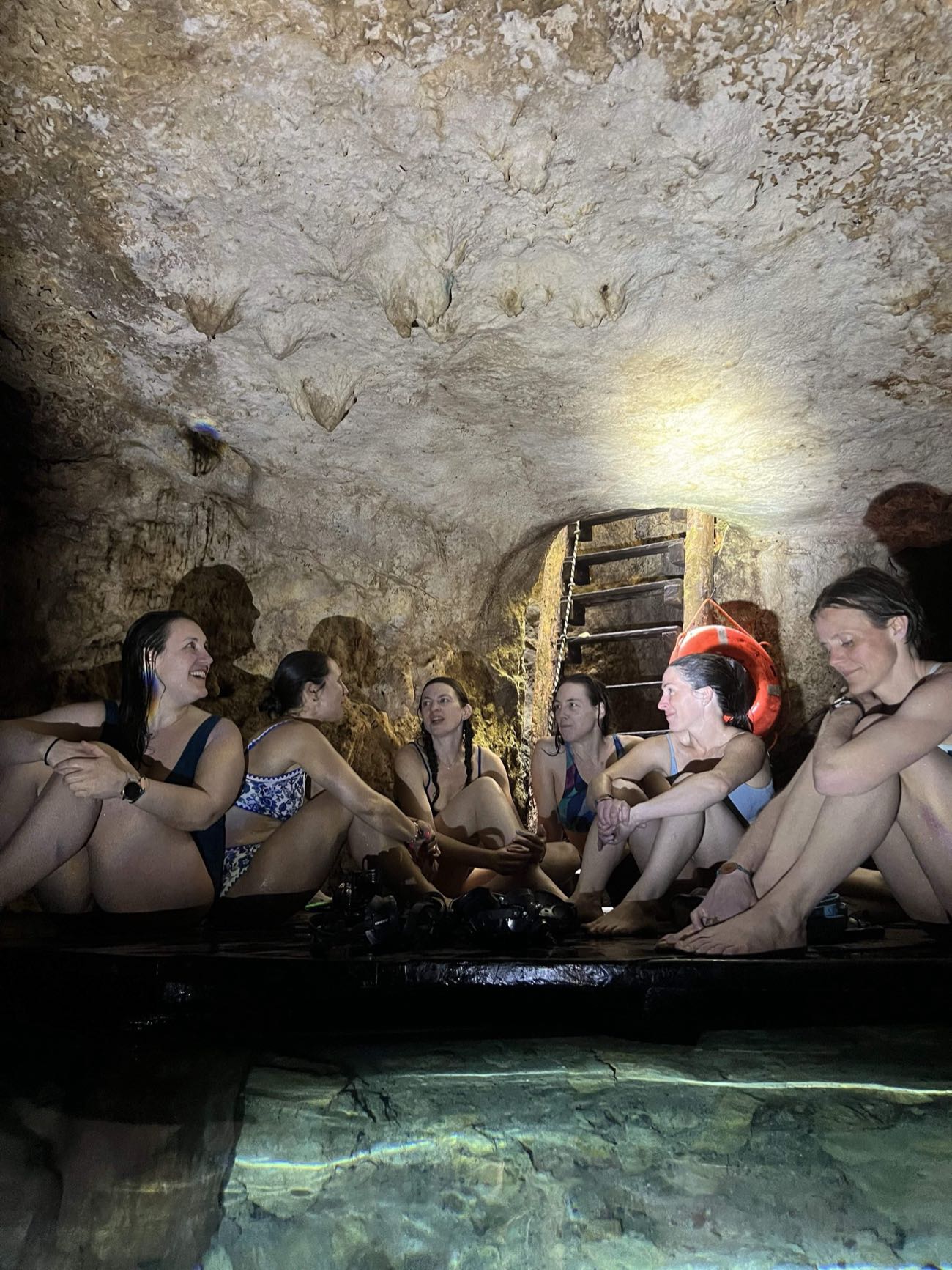 Group of friends resting together in a private cave cenote near Tulum