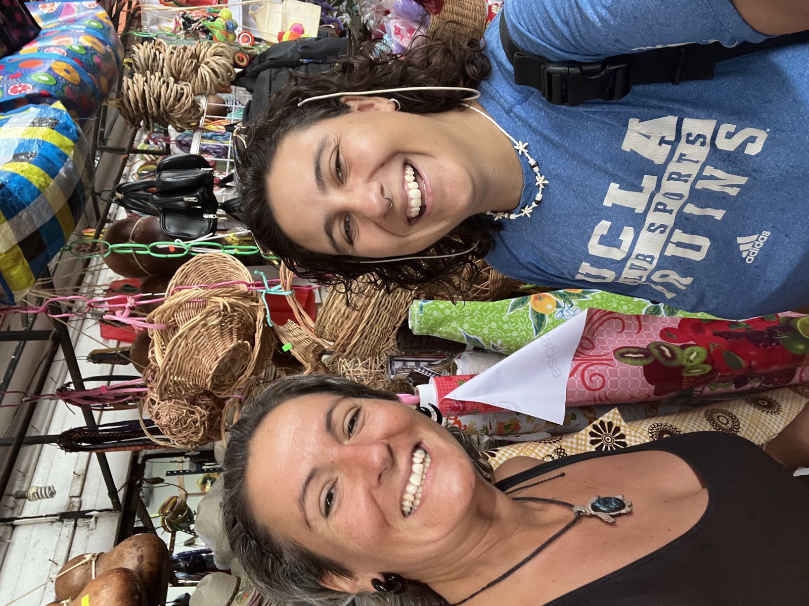 Two Camp Adventure Collective guides laughing together at a Tulum market stall